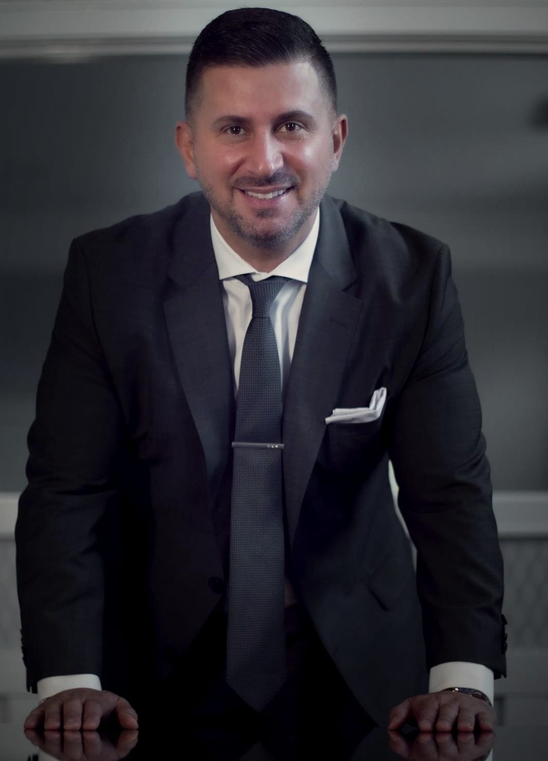 Bilal Hamie, owner of Emmar Realty, in a charcoal suit, smiling